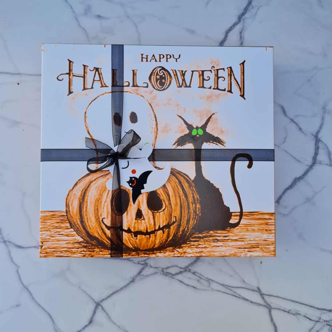 Halloween con calabaza, fantasma y gato negro en decoración festiva.