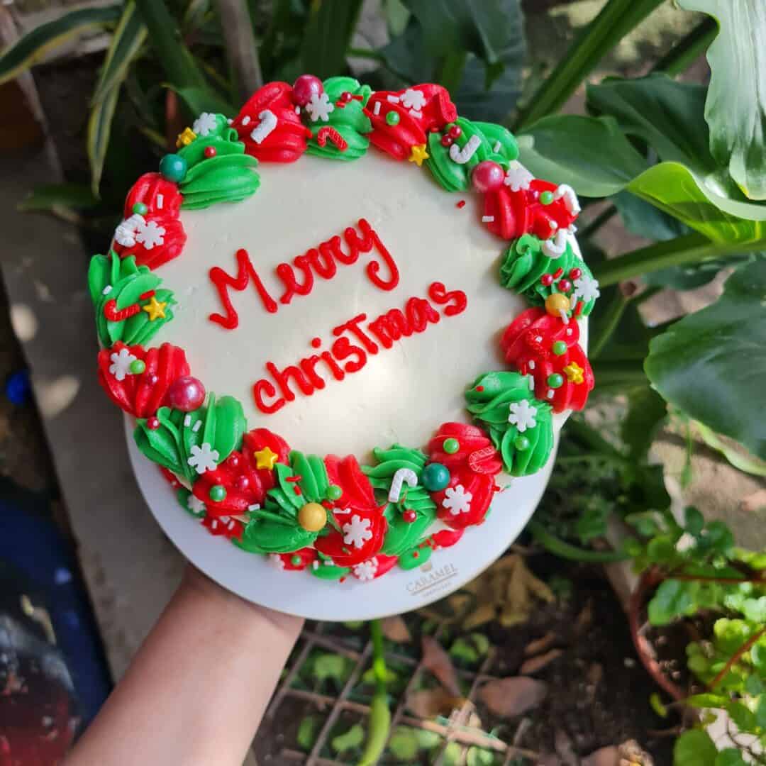 Árbol de Navidad de pastel con decoraciones festivas y mensaje de "Merry Christmas".