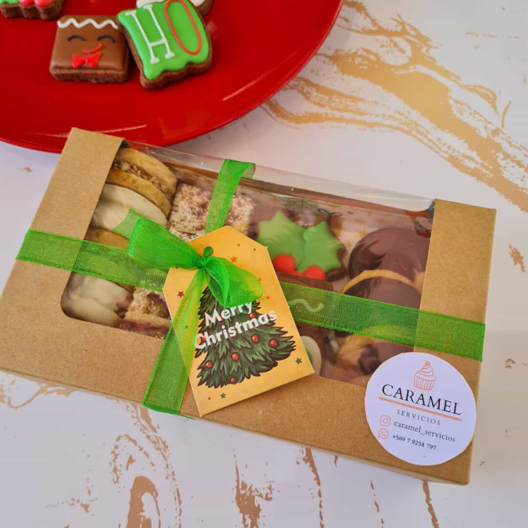 Pastelería online con caja de galletas y dulces navideños, decorada con lazo verde y etiqueta de Fel.
