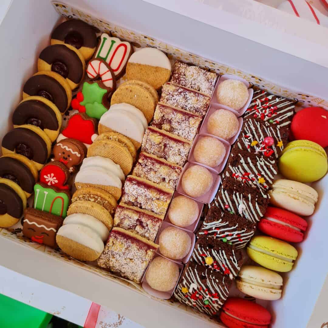 Selección de deliciosos postres y pastelería francesa en caja navideña.