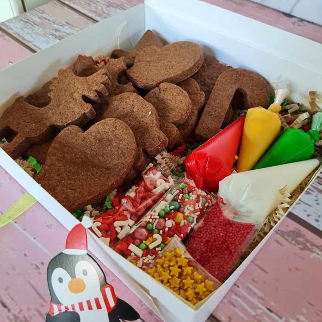 Galletas navideñas decoradas con glaseado y confites en caja festiva.