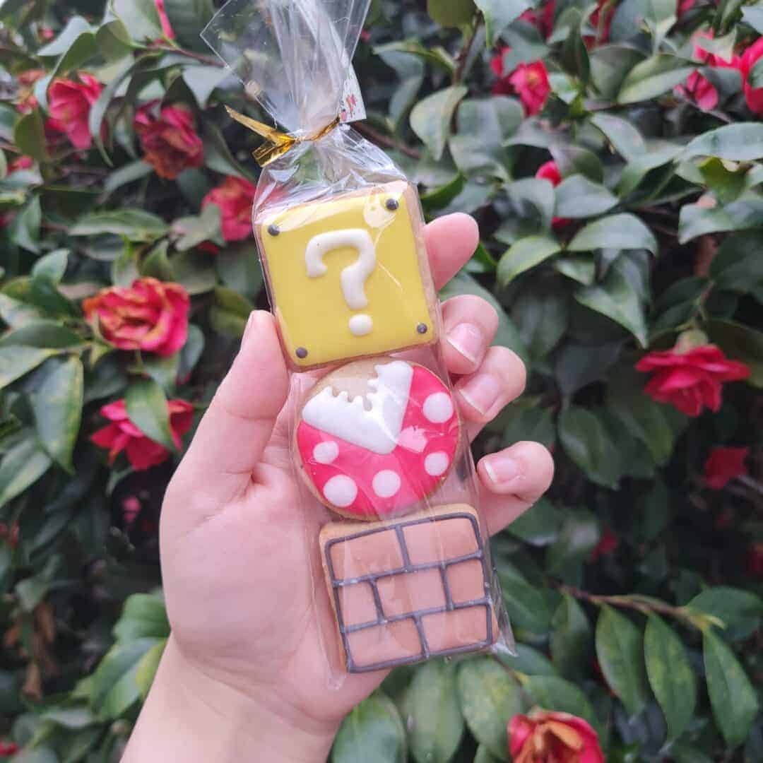 Galletas decoradas con temática de videojuegos y rompecabezas en paquete transparente.