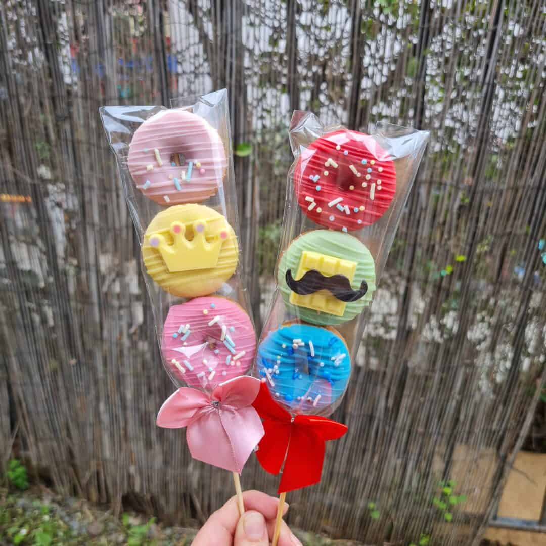 Brocheta de mini donuts decorados con colores y detalles divertidos.