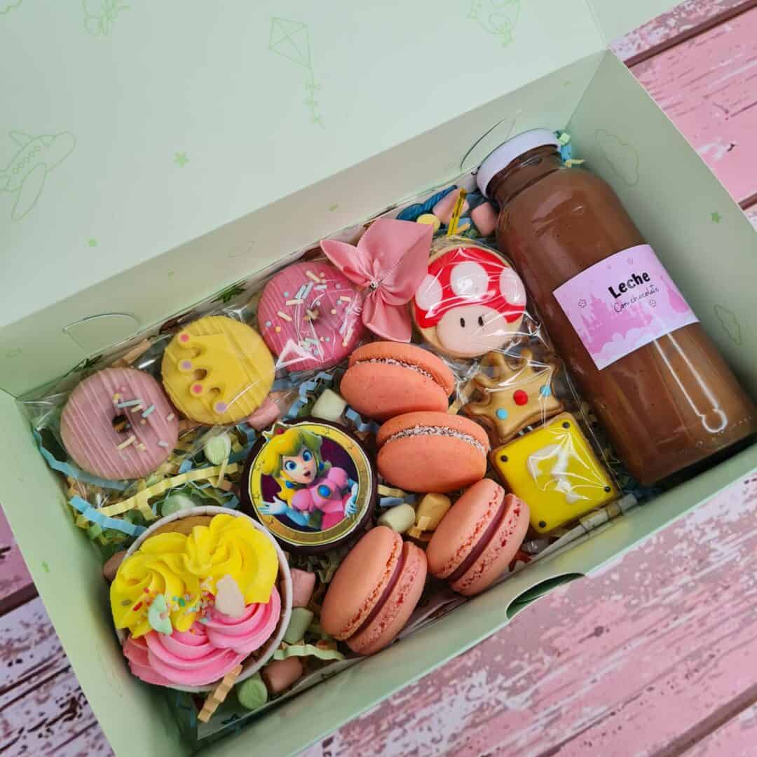 Caja con dulces y bebidas para celebración del Día de la Niñez en la pastelería online Caramel Servi.