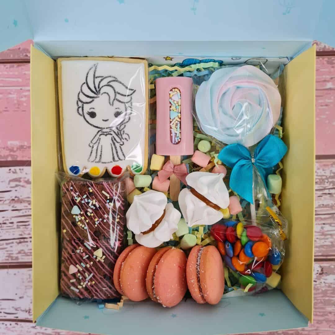 Caja con dulces y decoraciones para el Día de la Niñez, temática infantil.