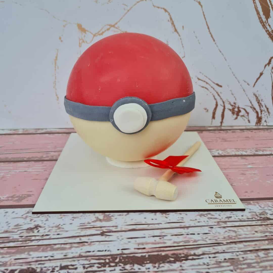 Pokéball de pastel con cometa decorativa, ideal para fiestas temáticas y celebraciones infantiles.