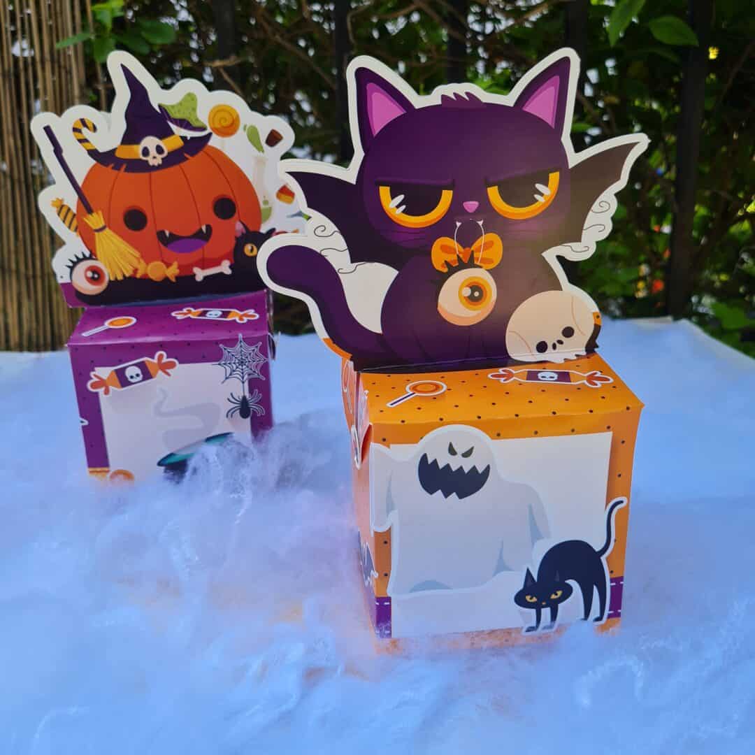 Halloween decor with cute black cat and pumpkin figures for celebration.