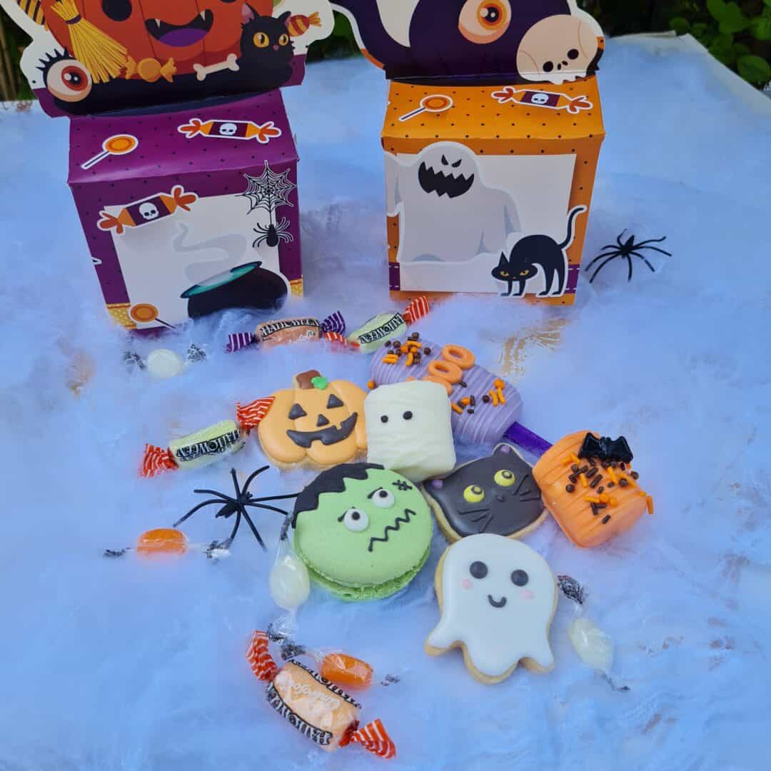 Dulces temáticos de Halloween con empaques decorativos y caramelos en un fondo blanco.