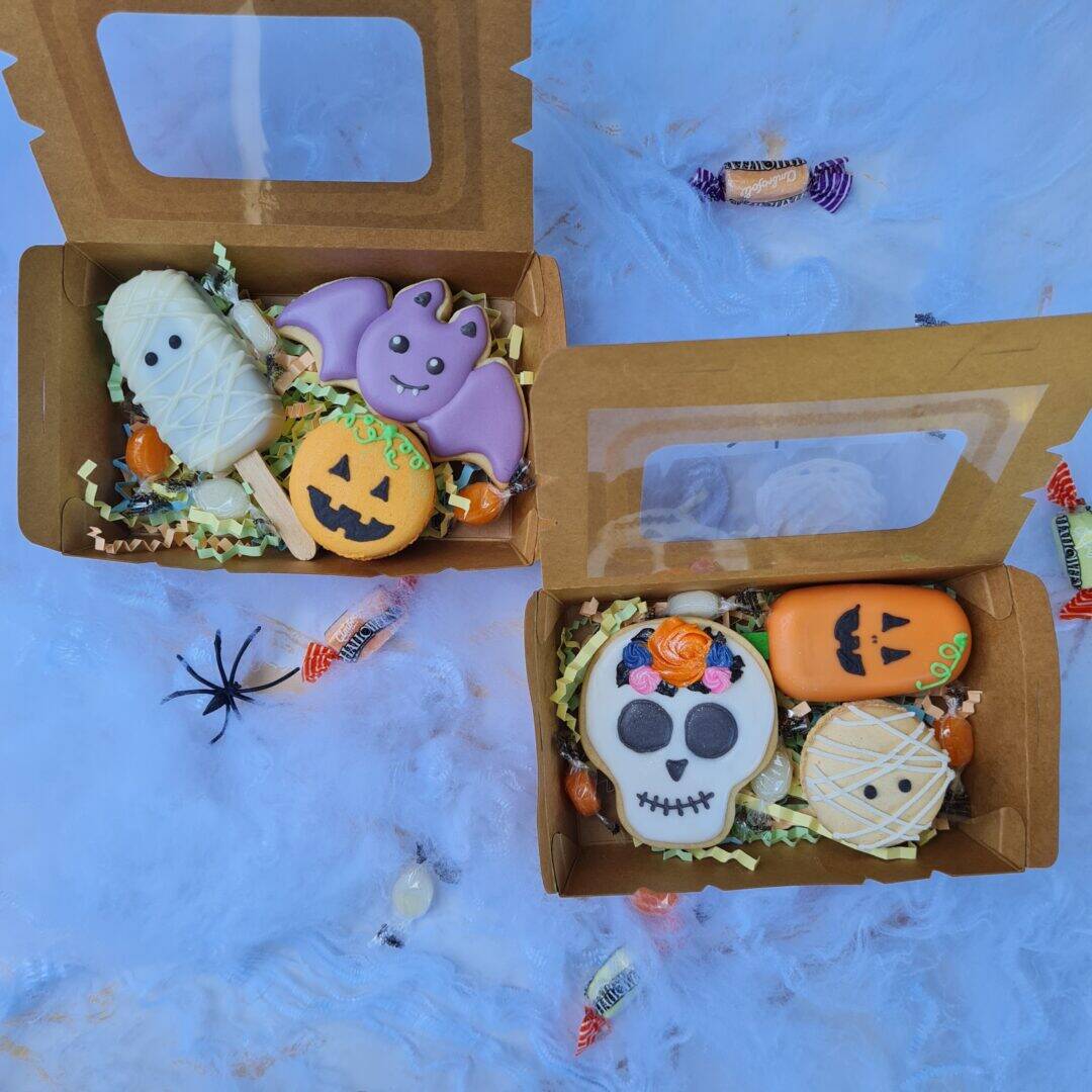 Calificación de la etiqueta ALT: Dulces de Halloween en cajas de cartón con decoraciones temáticas.