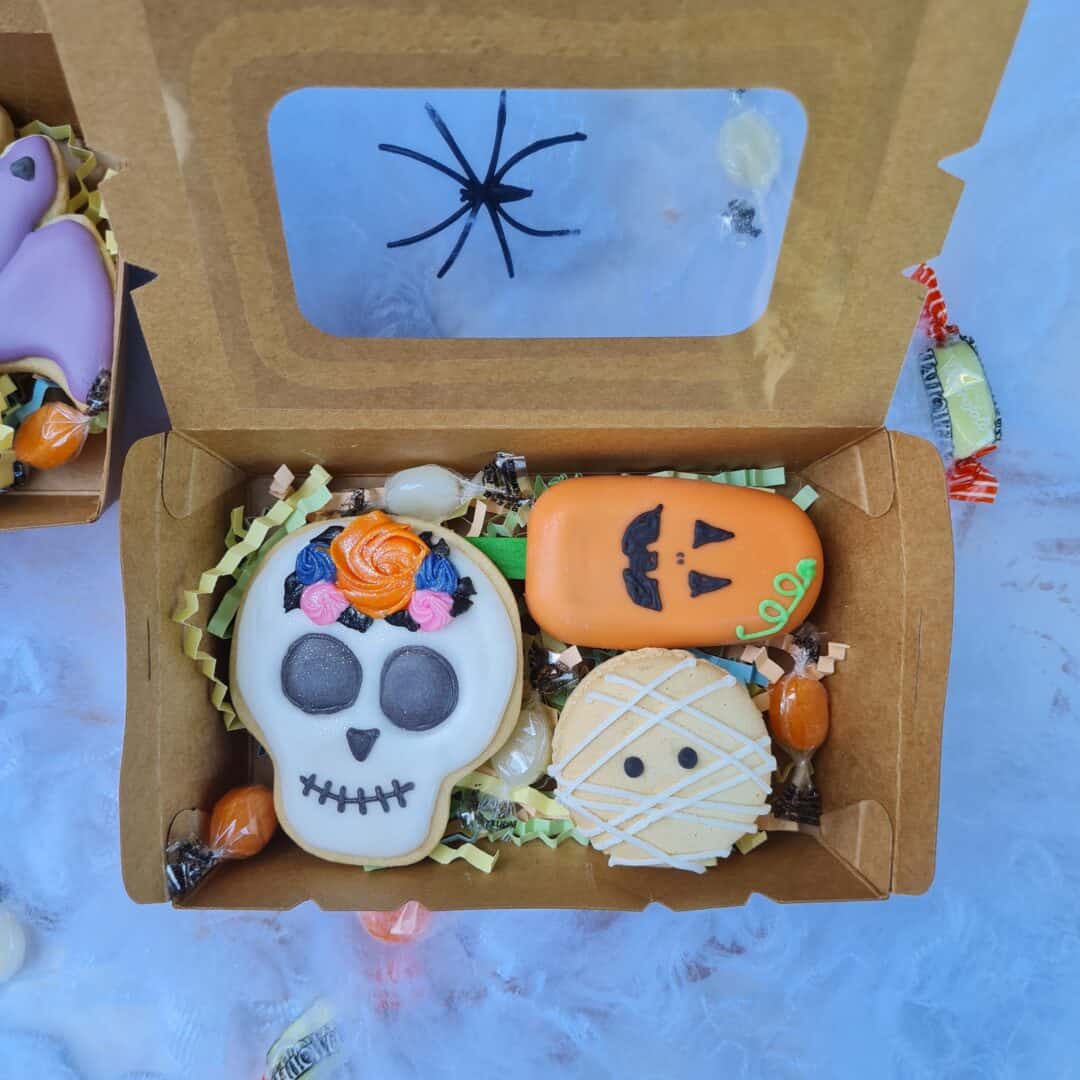 Calavera y calabaza de galleta decoradas para Halloween en caja de cartón.
