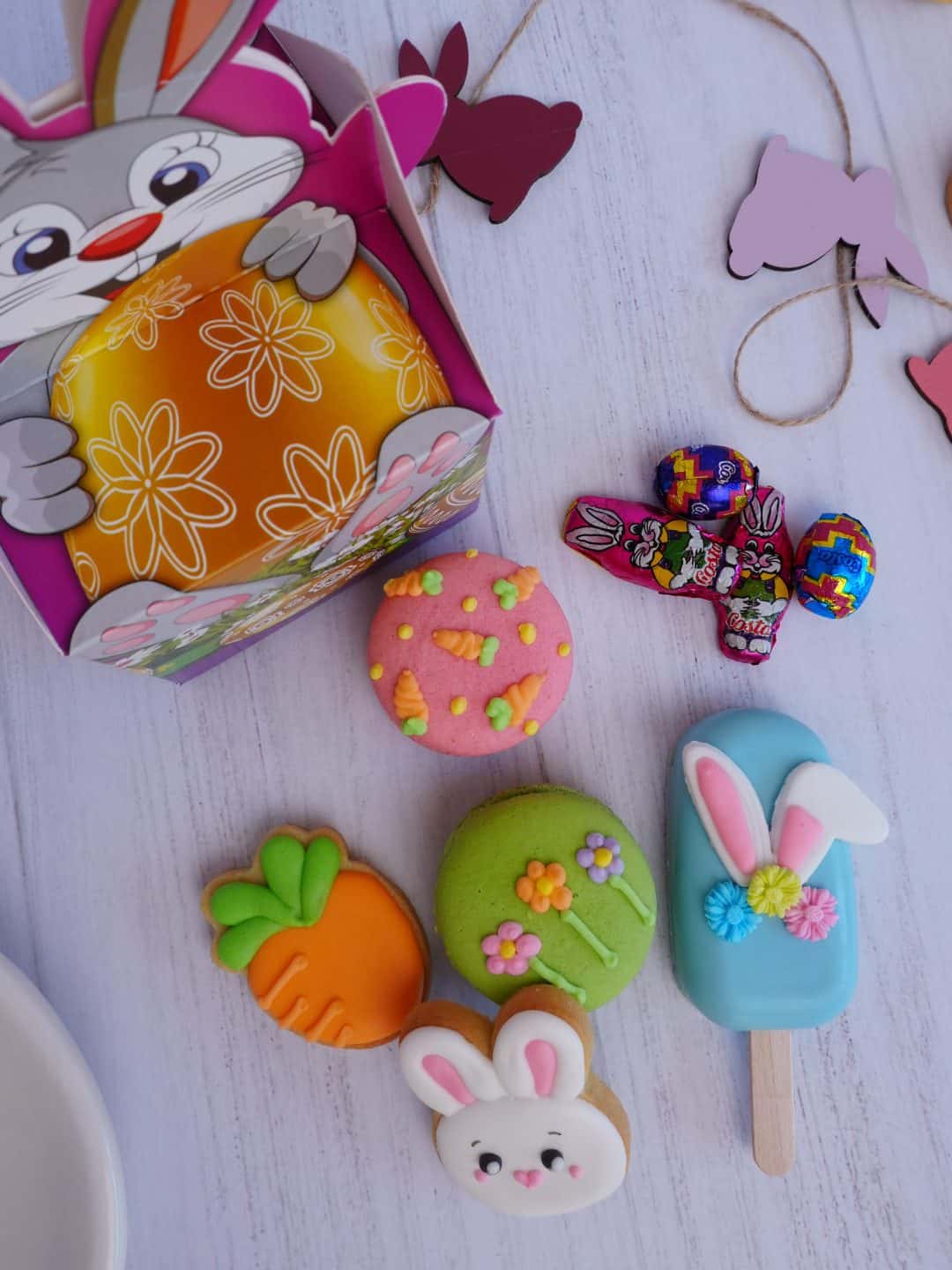 Minibox de Pascua con popsicle decorado, macarons, minigalletas glaseadas y huevitos de chocolate.