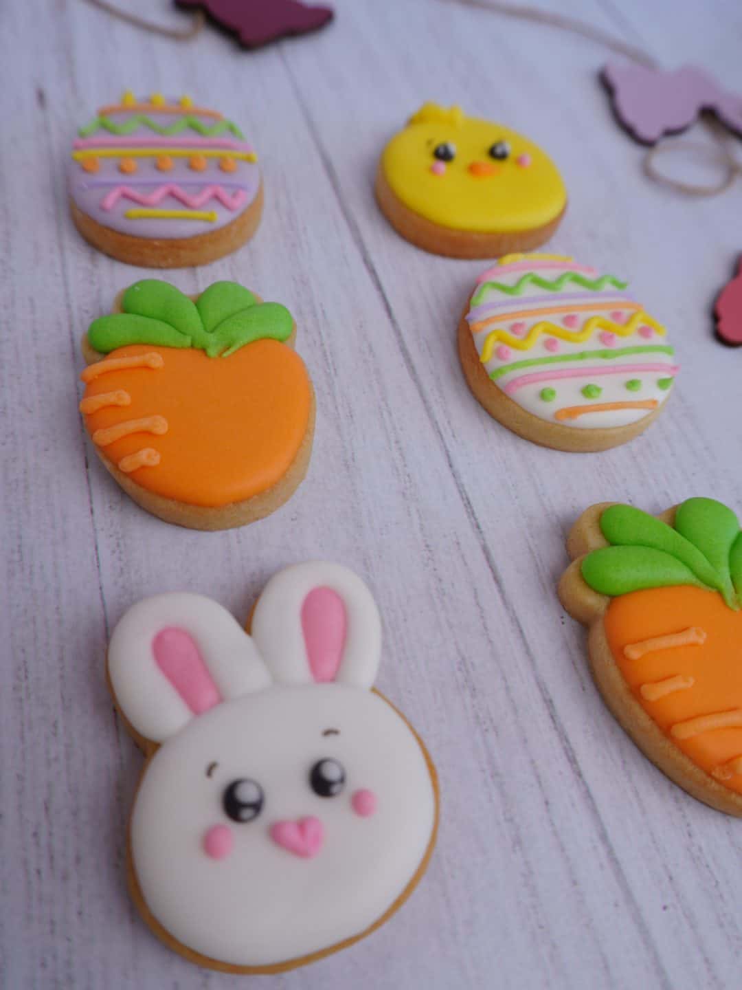 Galletas decoradas de Pascua con conejito, pollito y zanahorias, ideales para celebraciones primaver.