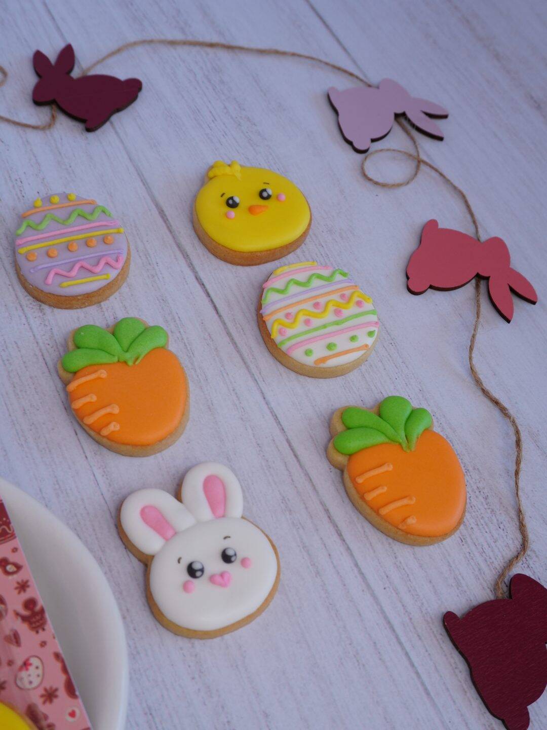 Galletas decoradas de Pascua con conejitos, huevos y zanahorias en colores pastel.