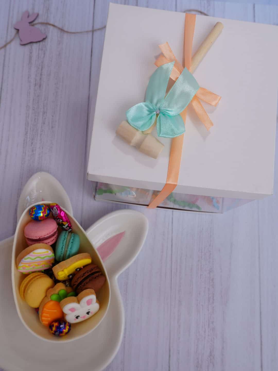 Huevo XL relleno de Pascua con macarons, galletas decoradas, huevitos de chocolate y martillo.